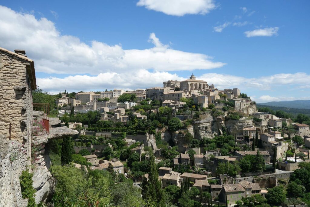 Photo by Yu Han Huang Discover the charming hilltop village of Gordes with its historic stone buildings and lush greenery.