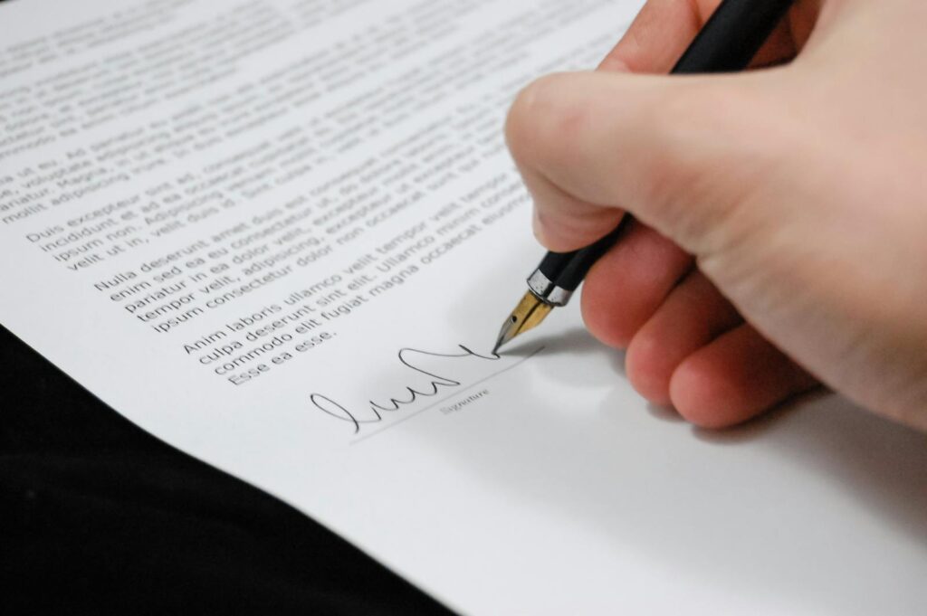 Photo by Pixabay Close-up of a hand signing a legal document with a fountain pen, symbolizing signature and agreement.